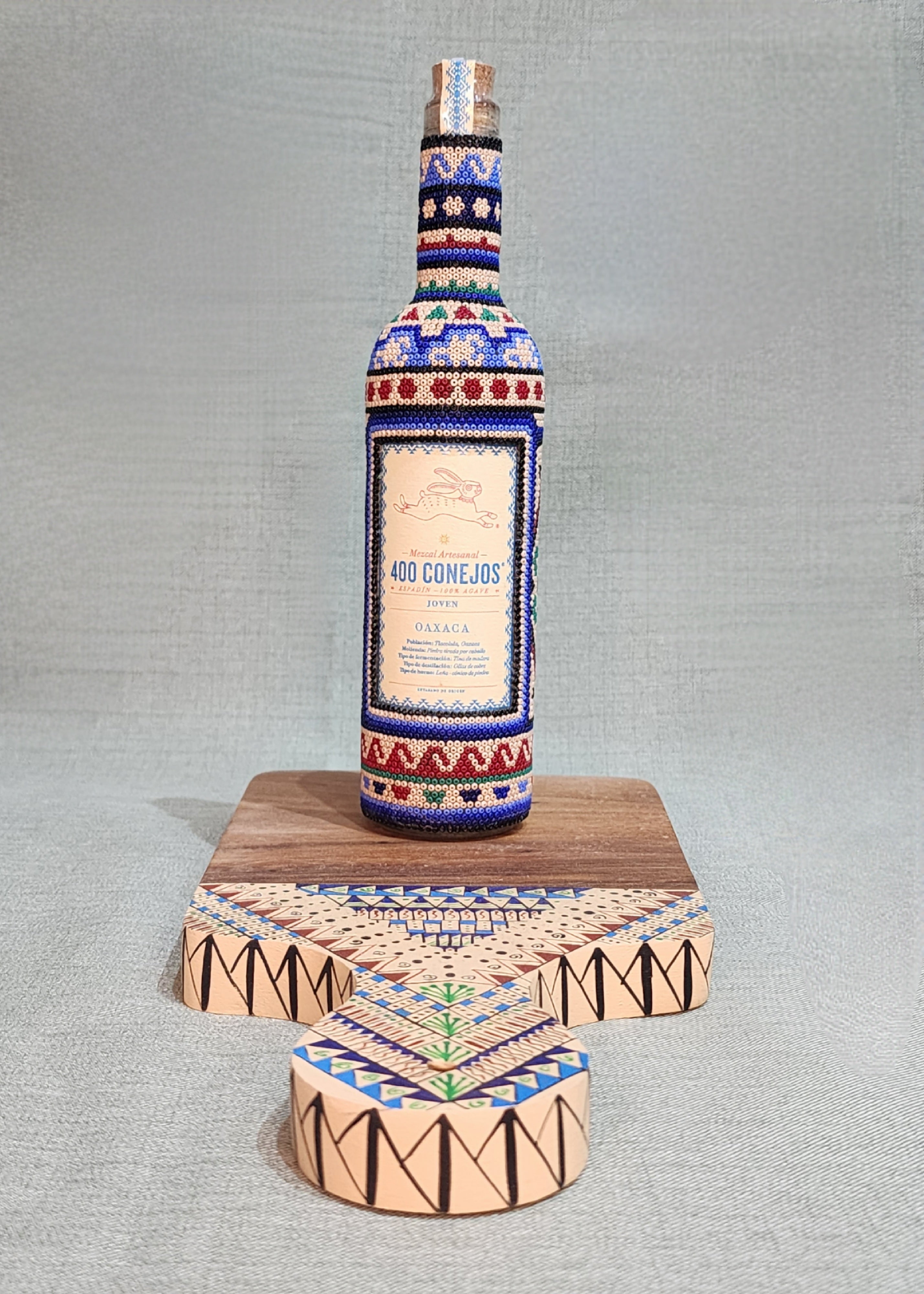 Botella de Mezcal con tabla de parota.